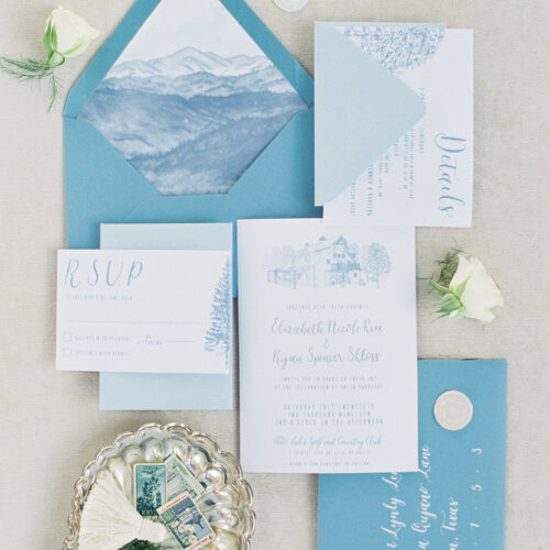 Minimalistic Blue Accent Invitation for a New Mexico Destination Wedding with Venue Illustration, Watercolor, and Calligraphy on Woodgrain Paper by CallIRosa
